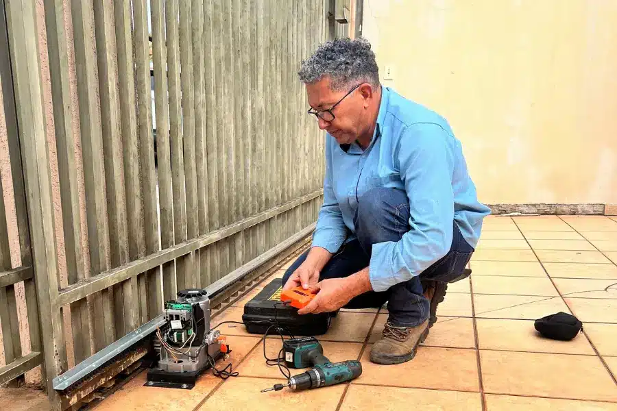 Técnico inspecionando o motor de um portão de correr