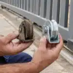 Técnico comparando roldana de portão desgastada com roldana nova
